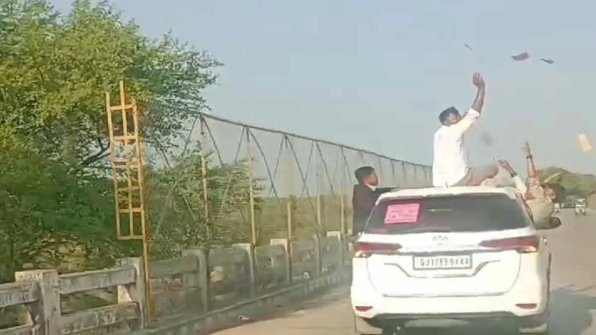 रीवा की सड़क पर नोटों की बारिश, चलती कार की छत पर बैठकर युवक की हीरोगिरी